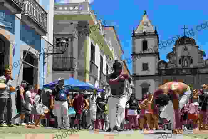 A Group Of Capoeira Dancers Performing On The Cobblestone Streets Of The Pelourinho District In Salvador, Brazil, With Colorful Costumes And Energetic Movements, Surrounded By Onlookers. Brazil Salvador And Its Region: An Invitation To Travel And Taste In A Colorful Vibrant And Welcoming Brazilian Region (Voyage Experience 11)